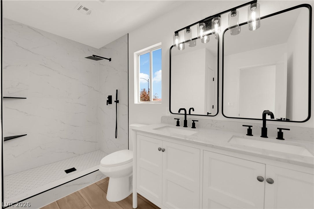 Clean lines and modern hardware define this light-filled bath featuring a tiled walk-in shower.