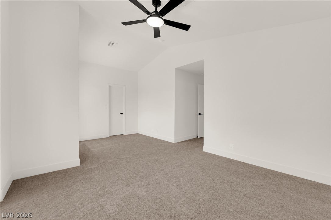 High vaulted ceilings and plush carpeting create a spacious feel in this bedroom.