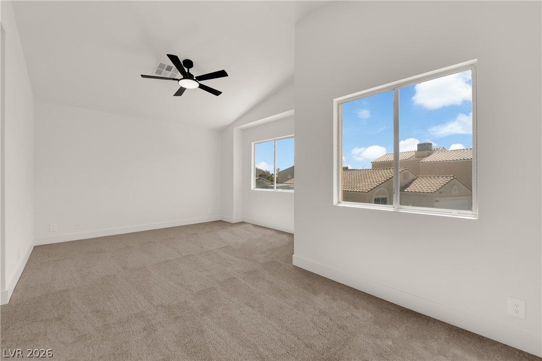 Vaulted ceilings and broad windows define this plushly carpeted upper-level room.