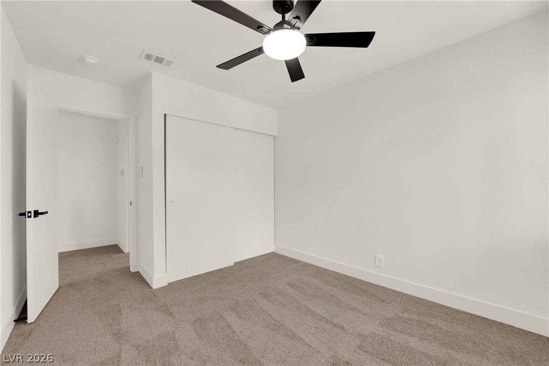 Soft carpeting pairs with neutral walls in this comfortable secondary bedroom.