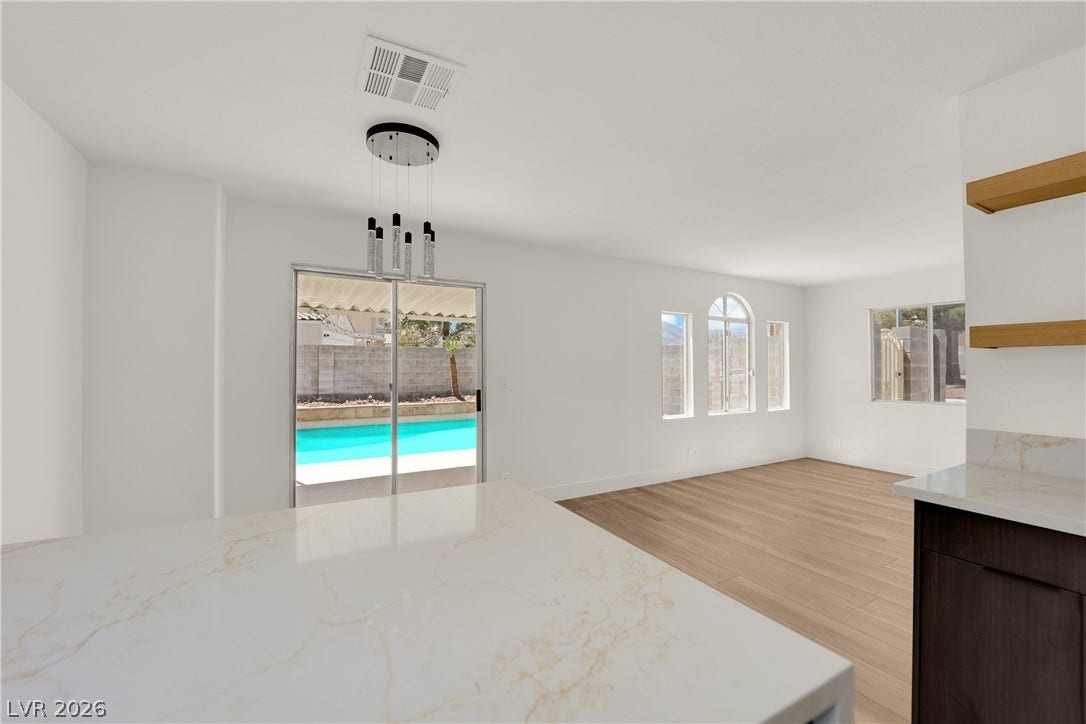 Sliding doors open directly to the sparkling pool area from this bright kitchen.