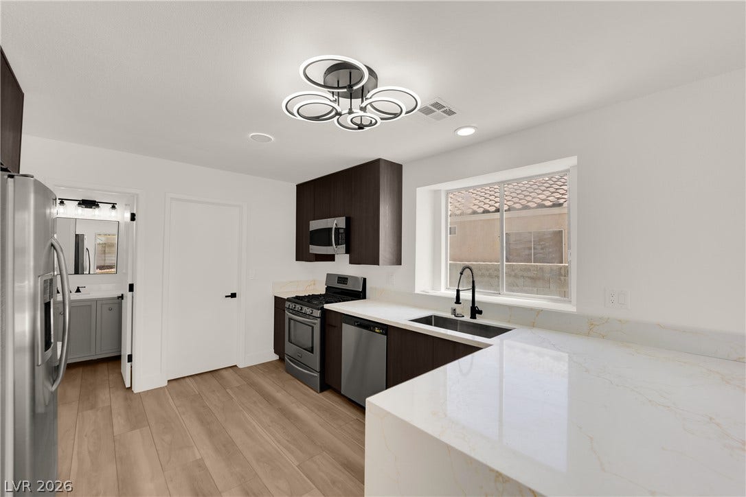 Gleaming stone countertops and modern stainless steel appliances define this beautifully updated kitchen.