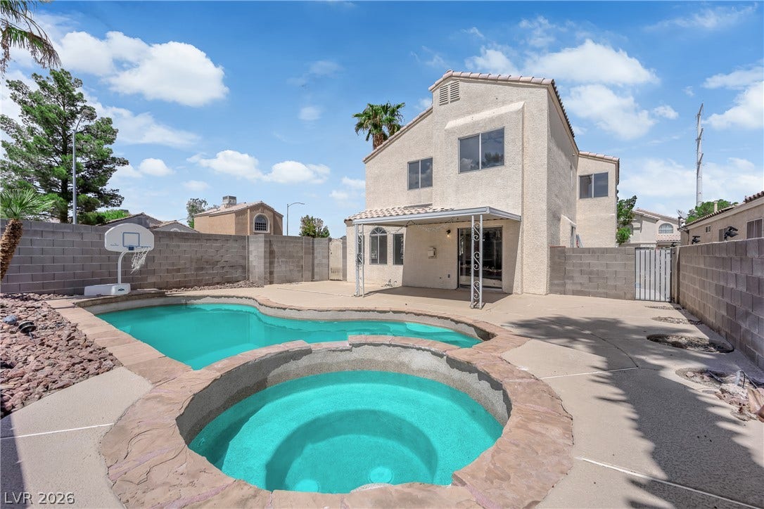 A private backyard oasis features an in-ground swimming pool and an integrated spa.