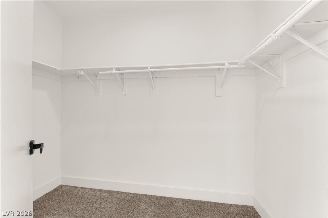 Ample hanging rods and shelving maximize storage potential in this walk-in closet.