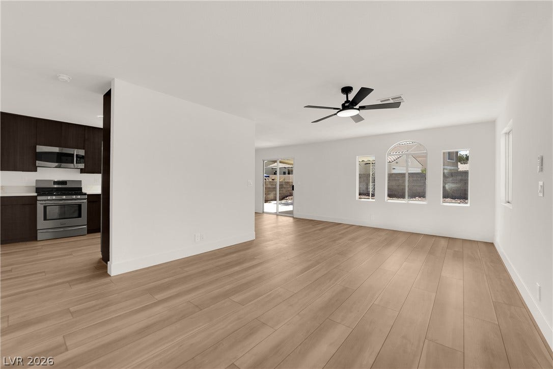 Smooth wood floors flow throughout a versatile living space bordering the modern kitchen.