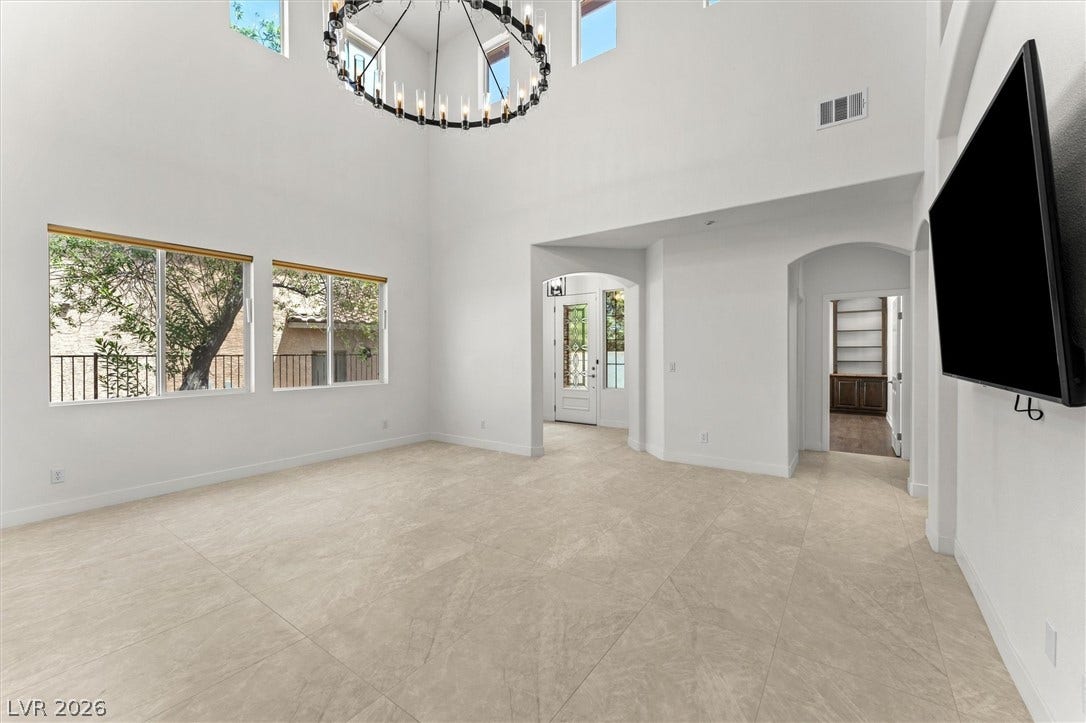 215 Sunset Shower Drive, Henderson, NV 89012 Double-height ceilings and large-format tile flooring define this airy architectural space.