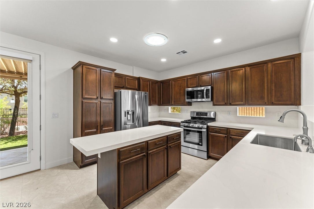 215 Sunset Shower Drive, Henderson, NV 89012 Rich wood cabinetry contrasts beautifully with pristine white countertops in this culinary space.