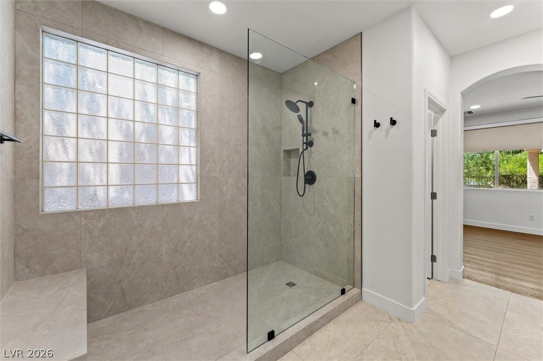215 Sunset Shower Drive, Henderson, NV 89012 Modern walk-in shower features large-format tile surrounds and a textured privacy window.