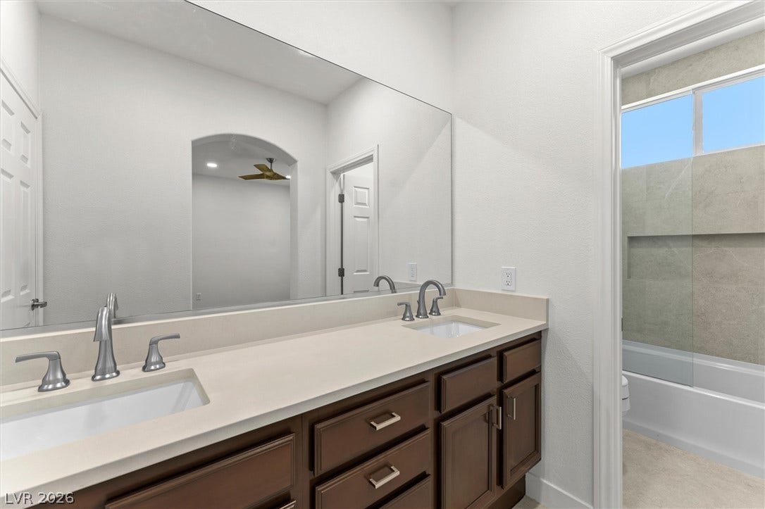 215 Sunset Shower Drive, Henderson, NV 89012 A spacious vanity with dual sinks sits adjacent to a modern tub and shower combination.
