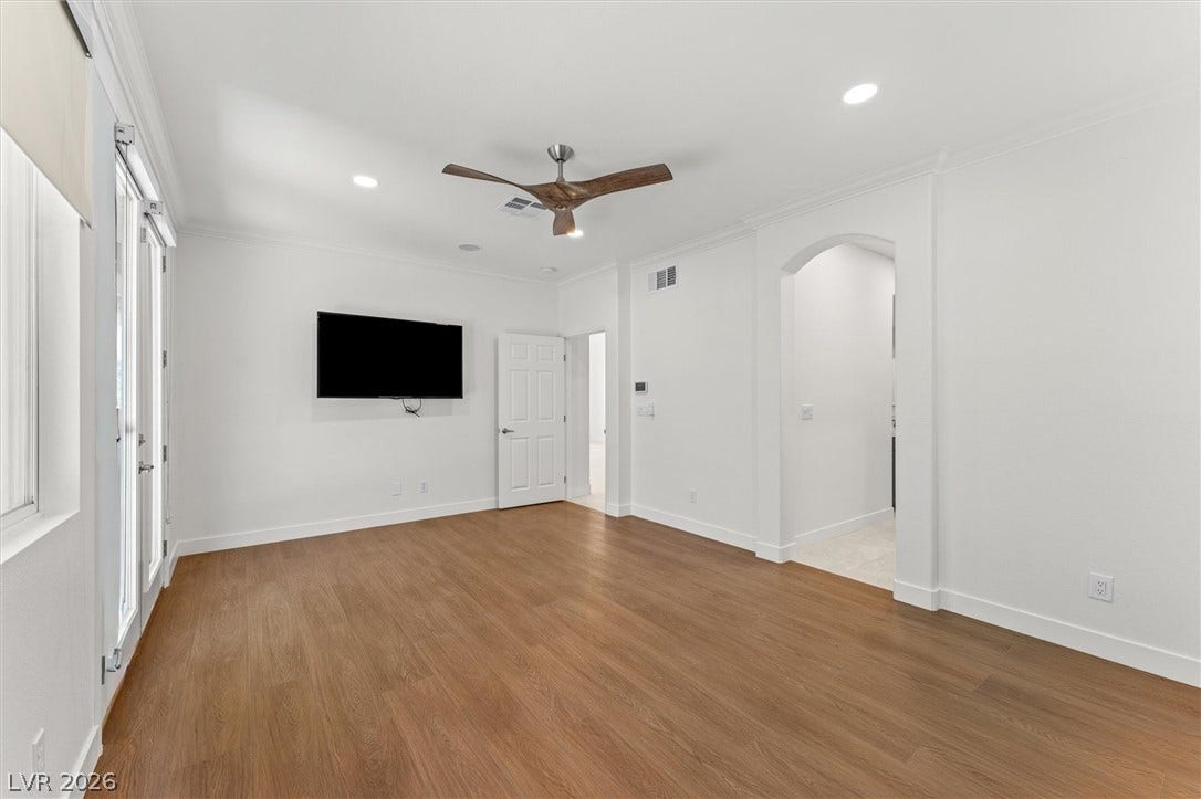215 Sunset Shower Drive, Henderson, NV 89012 Gleaming hardwood floors and classic arched doorways define this versatile secondary room.