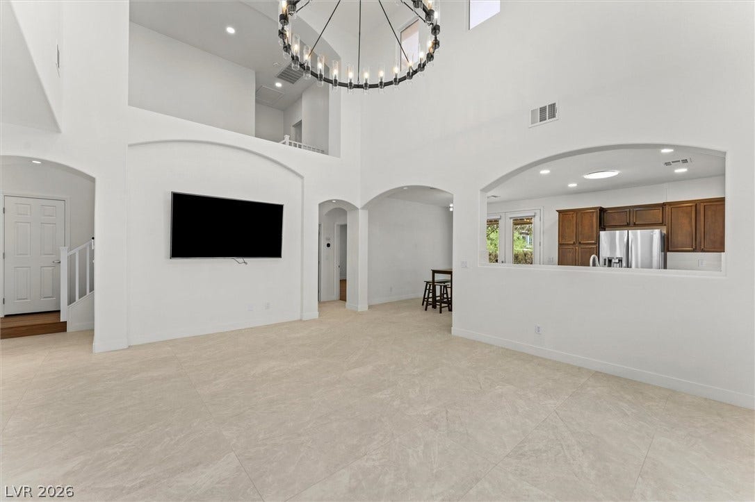 215 Sunset Shower Drive, Henderson, NV 89012 Towering ceilings and arched openings create an airy feel throughout the tile-floored living spaces.