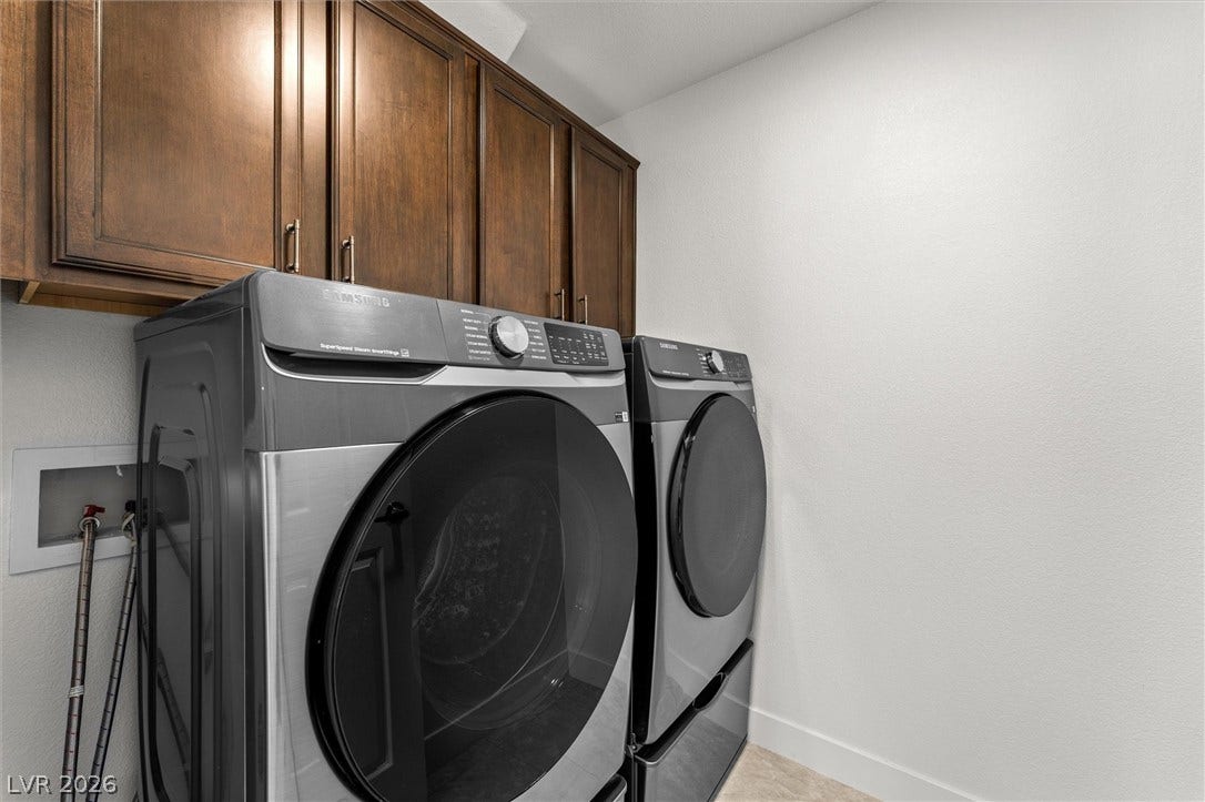 215 Sunset Shower Drive, Henderson, NV 89012 Rich wood cabinetry provides convenient storage overhead in this functional laundry space.