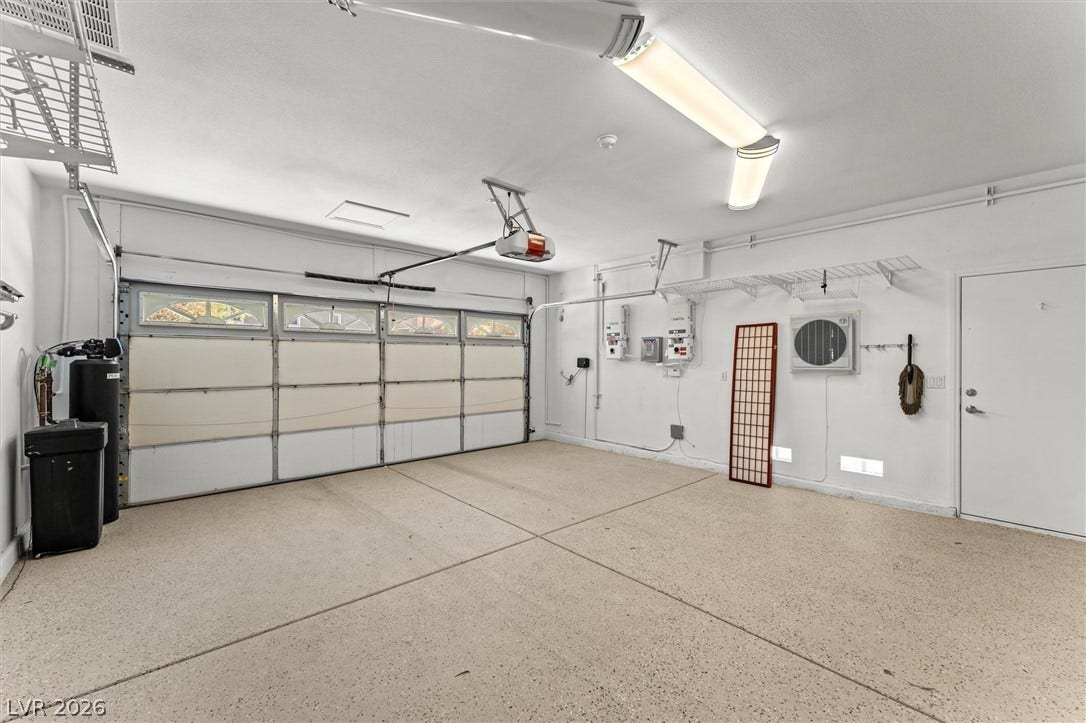 215 Sunset Shower Drive, Henderson, NV 89012 A spacious garage featuring durable textured flooring and pristine white walls.