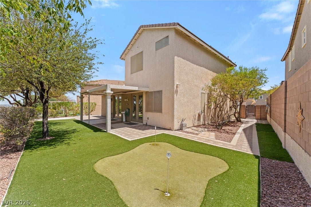 215 Sunset Shower Drive, Henderson, NV 89012 A private putting green highlights this manicured backyard retreat under open blue skies.