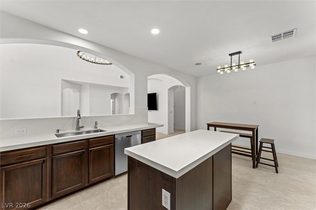 215 Sunset Shower Drive, Henderson, NV 89012 Rich wood cabinetry contrasts beautifully with clean white countertops and arched architectural details.