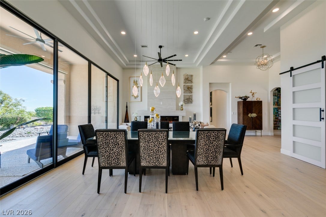 2532 Faiss Drive, Las Vegas, NV 89134 An elegant dining space features wide-plank wood flooring and massive sliding glass doors.
