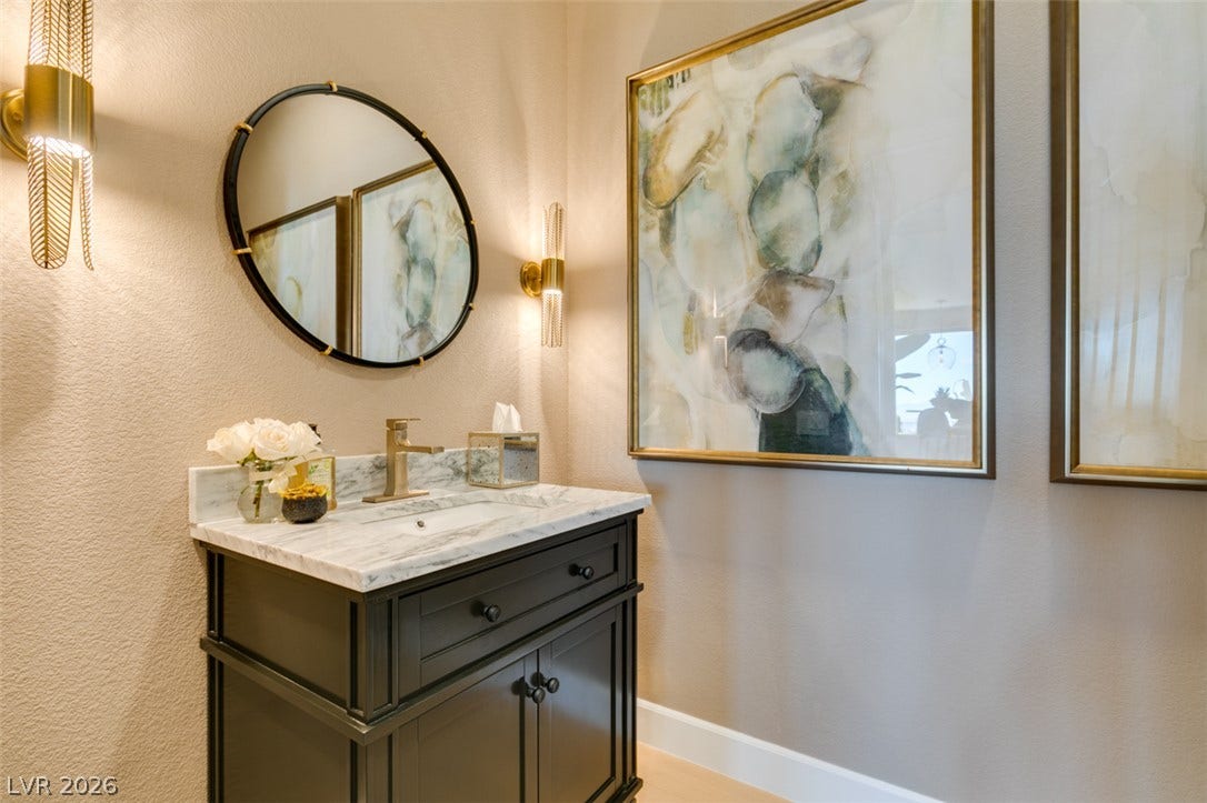 2532 Faiss Drive, Las Vegas, NV 89134 Elegant textured walls and marble counters define this refined powder room.
