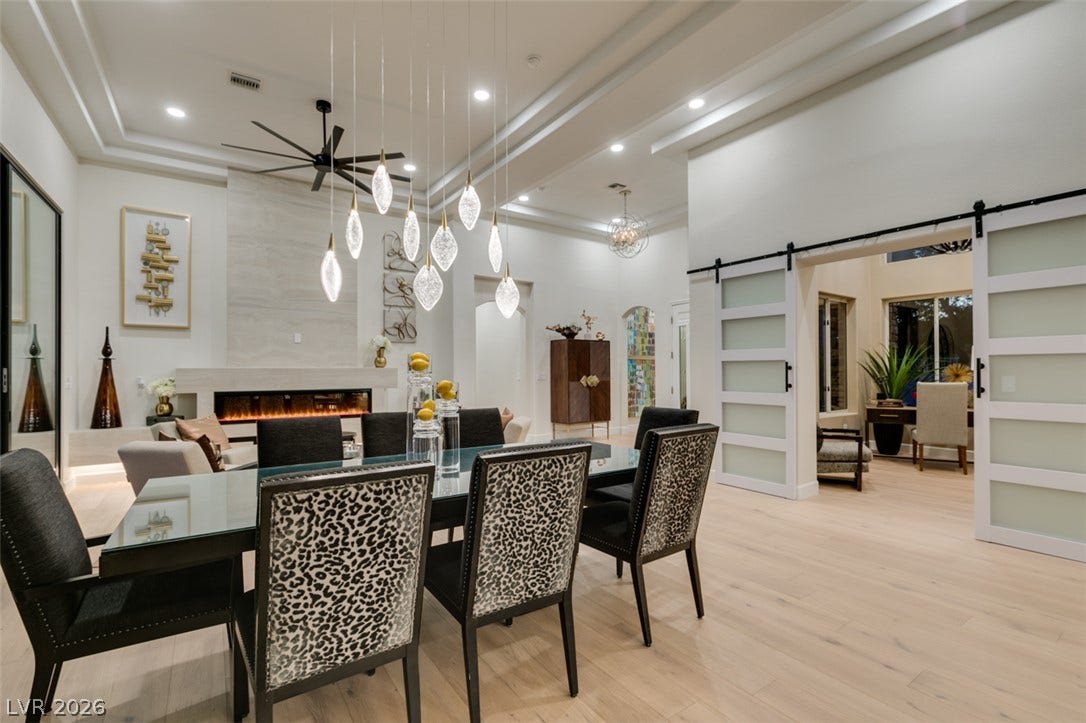 2532 Faiss Drive, Las Vegas, NV 89134 Multi-layered tray ceilings and expansive wood flooring elevate this grand open-concept dining space.
