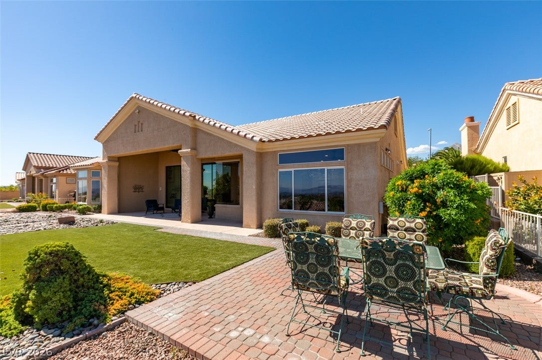 2532 Faiss Drive, Las Vegas, NV 89134 An inviting brick paver patio extends from the covered porch onto a manicured green lawn.
