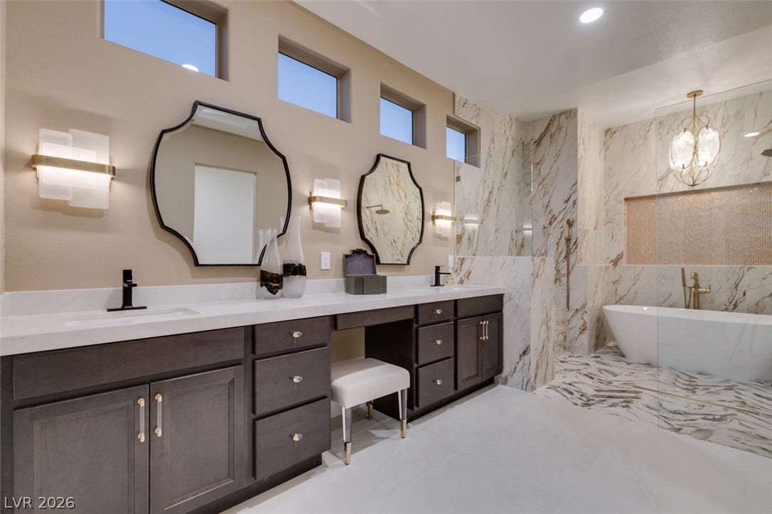 2532 Faiss Drive, Las Vegas, NV 89134 Elegant stone finishes and high clerestory windows elevate this luxurious spa-like primary bathroom.