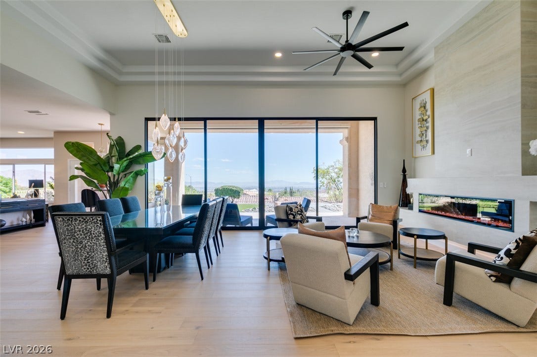 2532 Faiss Drive, Las Vegas, NV 89134 Soaring tray ceilings and a modern linear fireplace anchor this open-concept living and dining space.