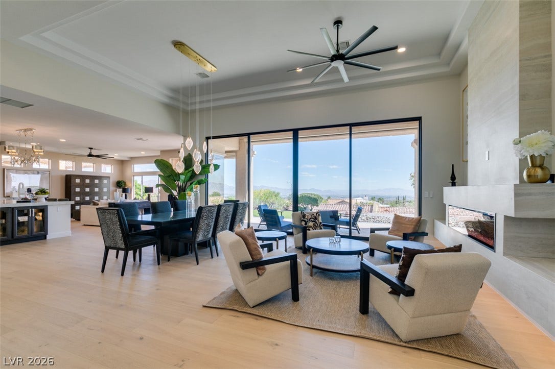 2532 Faiss Drive, Las Vegas, NV 89134 A spacious open-concept interior features wood floors, a modern fireplace, and large sliding glass doors.