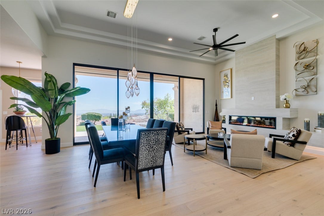 2532 Faiss Drive, Las Vegas, NV 89134 Sunlight streams through expansive sliding glass doors onto light wood floors in this open-concept layout.