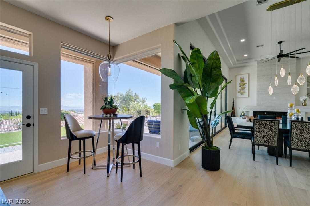 2532 Faiss Drive, Las Vegas, NV 89134 Sunlight streams through expansive windows across light hardwood flooring in this open-concept layout.