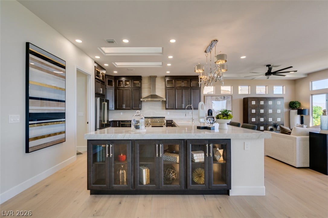2532 Faiss Drive, Las Vegas, NV 89134 Rich dark cabinetry and a waterfall-edge island anchor this modern culinary space.