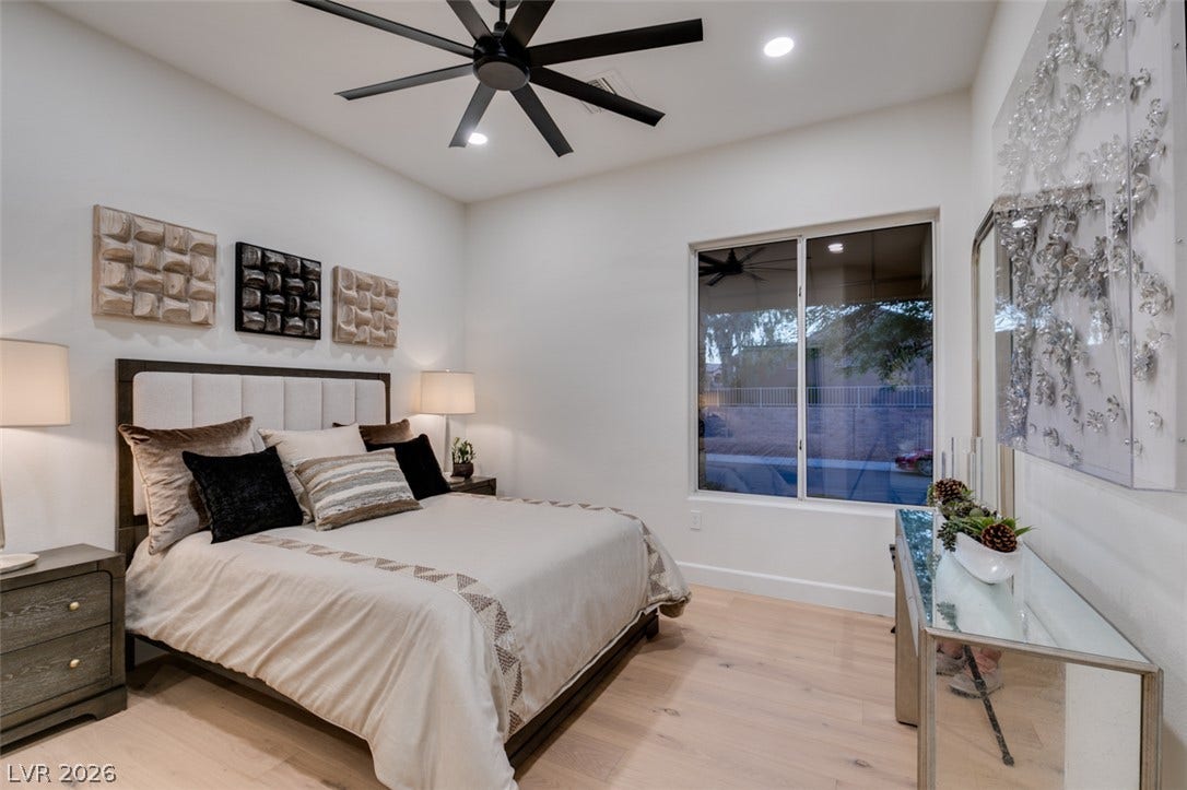 2532 Faiss Drive, Las Vegas, NV 89134 A light-filled bedroom boasts natural wood flooring and a large window looking outside.