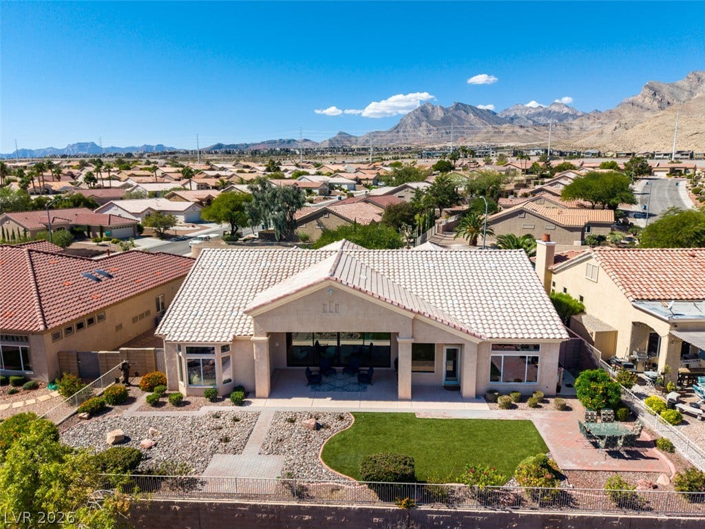 2532 Faiss Drive, Las Vegas, NV 89134 Dramatic mountain backdrops frame this single-story home featuring tile roofing and a manicured backyard.