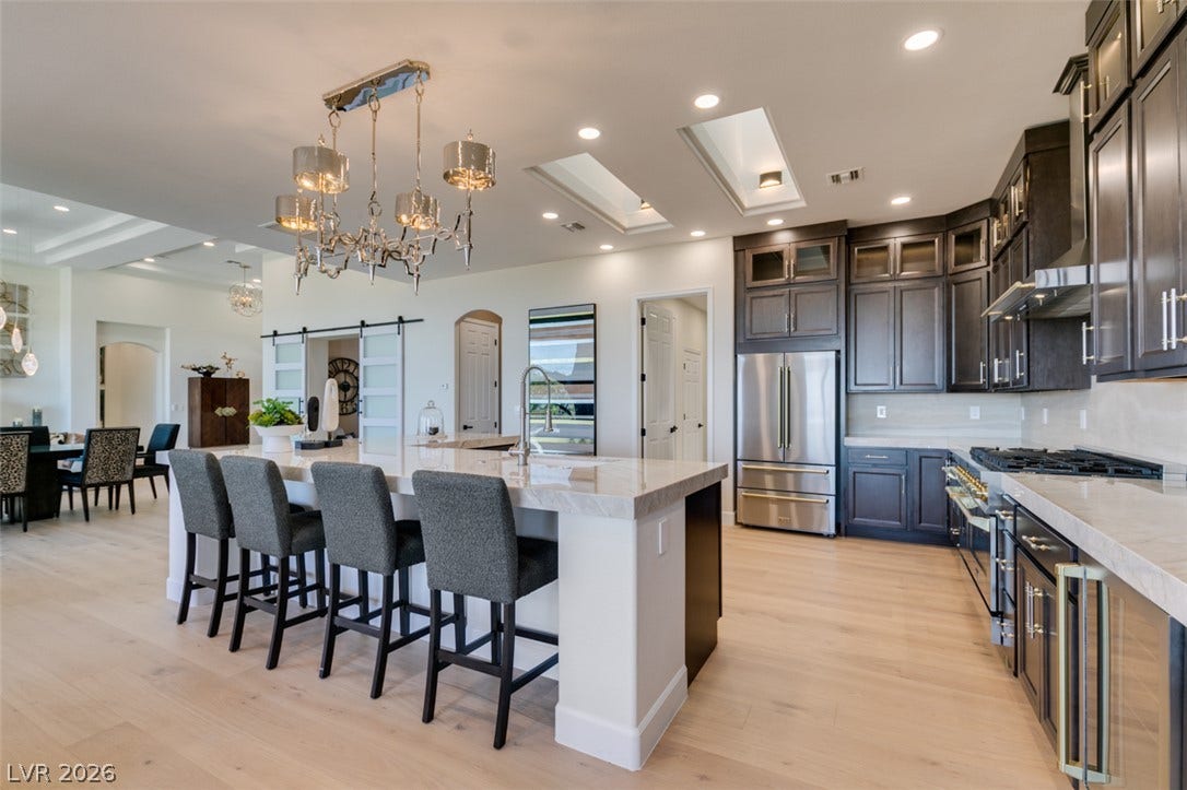 2532 Faiss Drive, Las Vegas, NV 89134 Double skylights and stone countertops elevate this expansive culinary space with hardwood flooring.