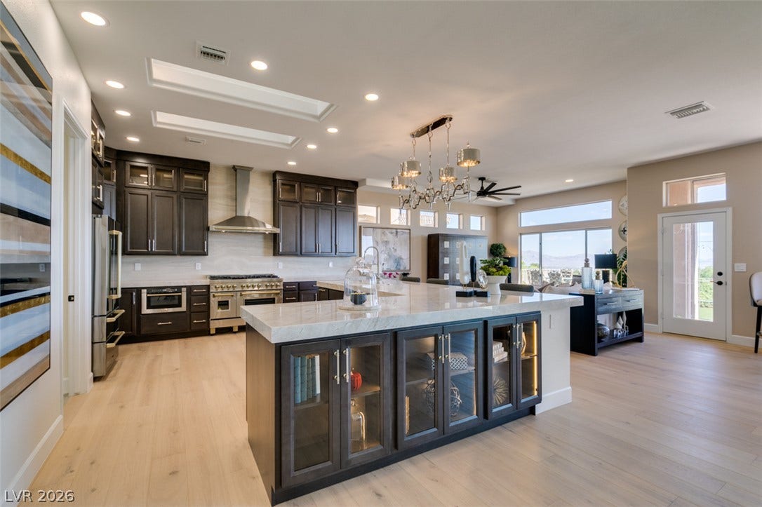 2532 Faiss Drive, Las Vegas, NV 89134 An expansive kitchen layout boasts premium cabinetry and high ceilings over light wood flooring.