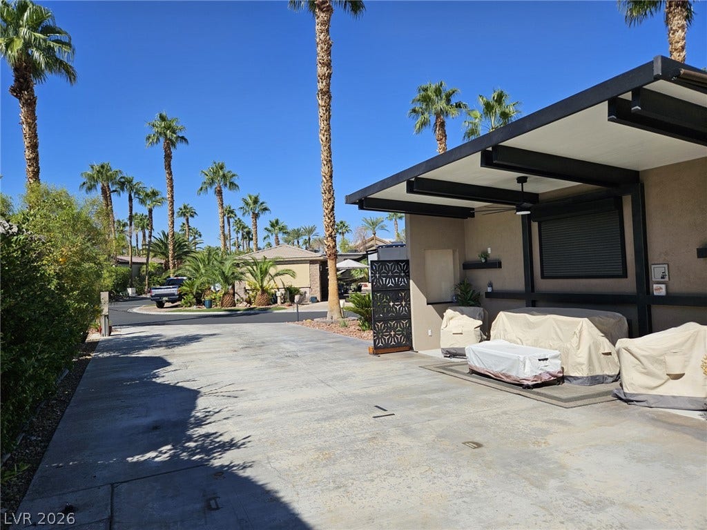 8175 Arville Street, #186, Las Vegas, NV 89139 Midcentury architectural lines define this covered outdoor space flanked by towering palm trees.