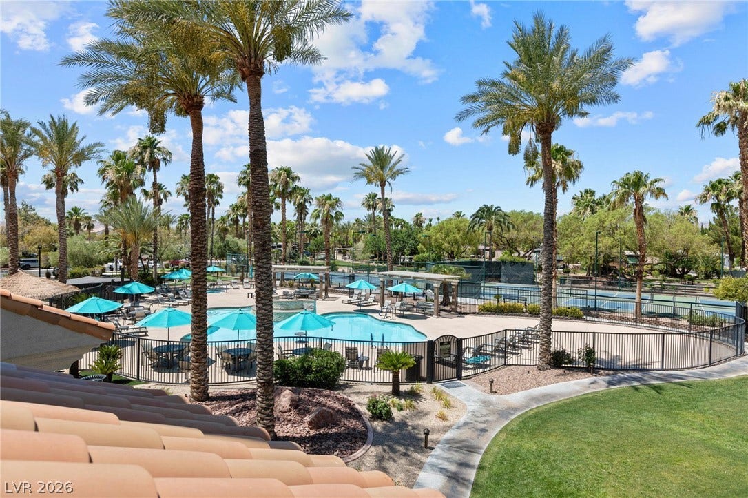 8175 Arville Street, #186, Las Vegas, NV 89139 Towering palm trees frame views of a community pool and tennis court under clear skies.