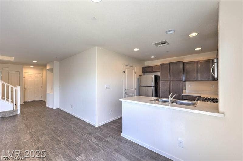 4134 San Cuervo Way, Las Vegas, NV 89115 Clean lines and wood-look flooring define this open layout connecting the kitchen and living areas.