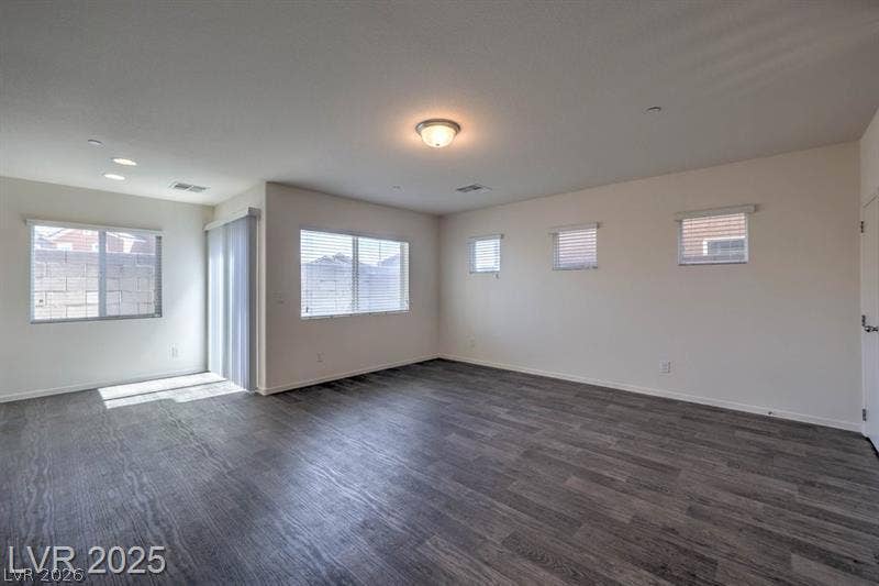 4134 San Cuervo Way, Las Vegas, NV 89115 A spacious interior showcasing durable wood-look flooring and multiple windows welcoming natural light.
