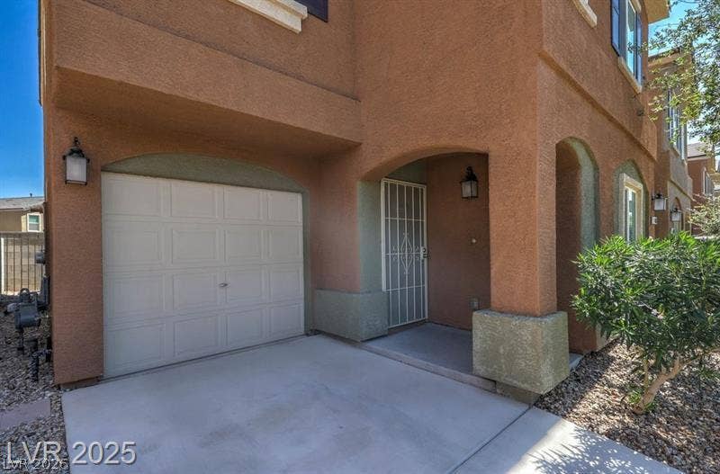4134 San Cuervo Way, Las Vegas, NV 89115 An inviting stucco exterior highlights the arched entryway and attached garage of this multi-level home.