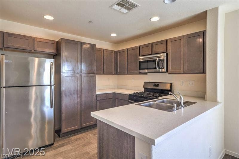 4134 San Cuervo Way, Las Vegas, NV 89115 Rich cabinetry and solid countertops define this streamlined kitchen space.