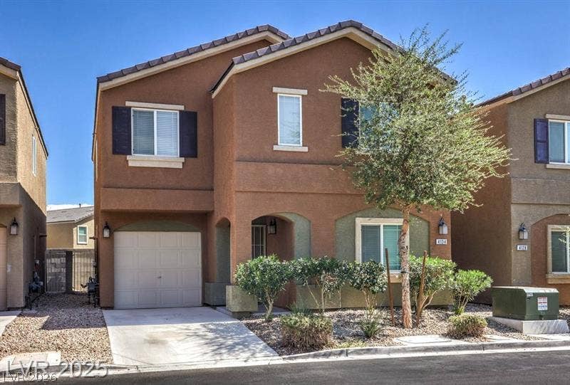4134 San Cuervo Way, Las Vegas, NV 89115 Earth-toned exterior surfaces pair with tiled roof gables and a neat paved driveway.