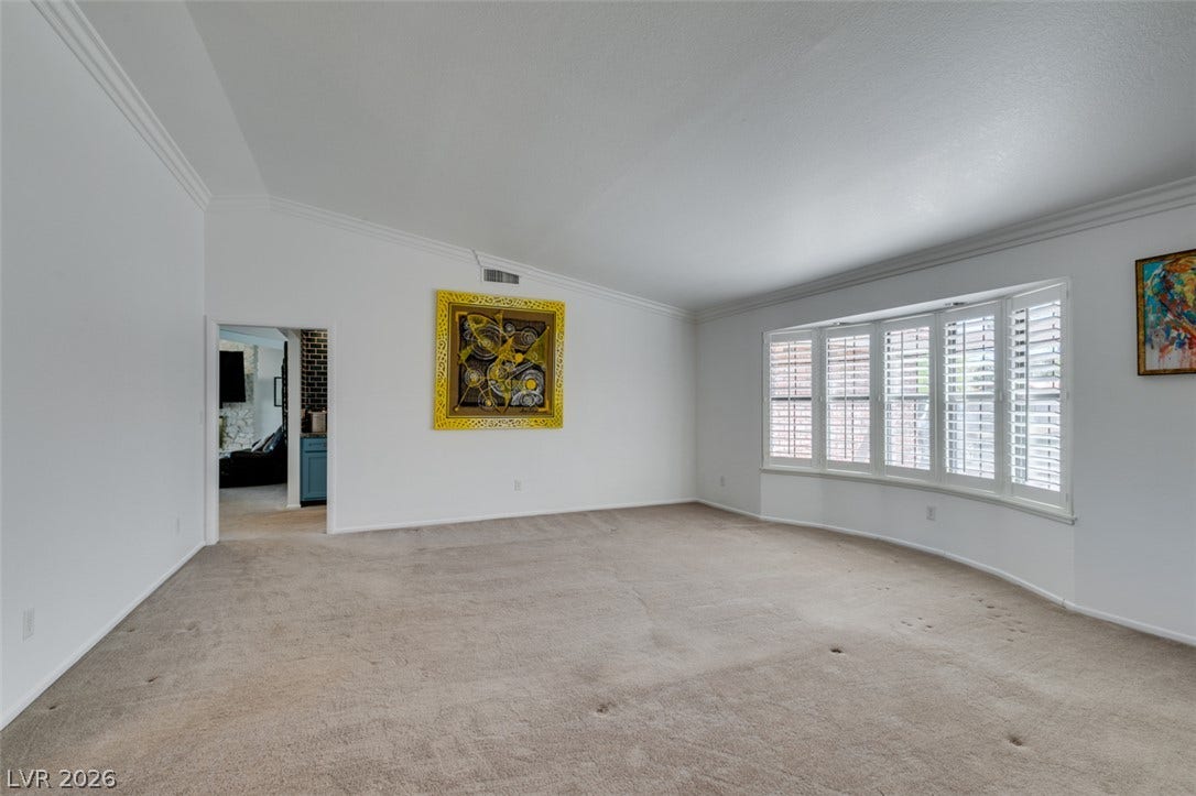 2246 Almart Circle, Henderson, NV 89014 An elegant bay window with plantation shutters anchors this carpeted living area.