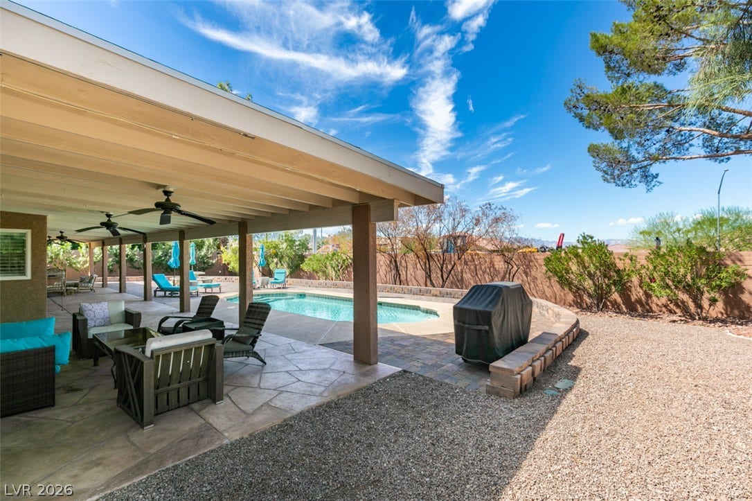 2246 Almart Circle, Henderson, NV 89014 An inviting covered patio steps down to a private swimming pool under wide desert skies.
