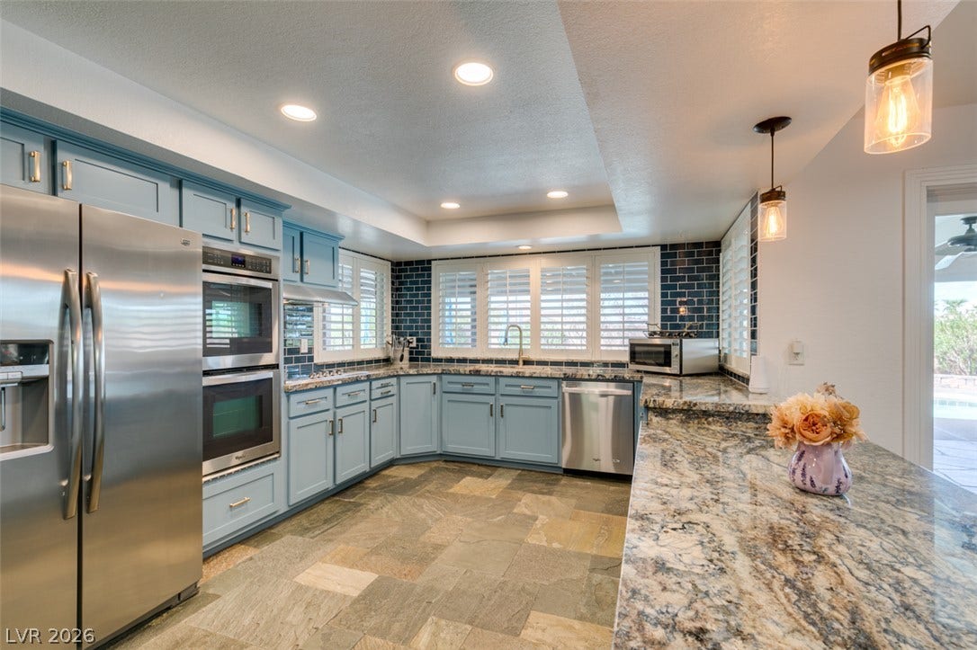 2246 Almart Circle, Henderson, NV 89014 Polished stone countertops complement the custom cabinetry and durable tile flooring in this kitchen.