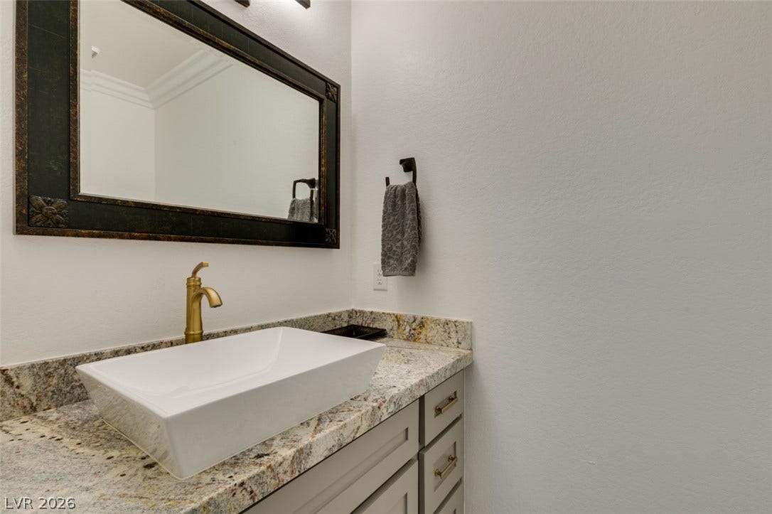 2246 Almart Circle, Henderson, NV 89014 An elegant vessel sink sits atop granite counters in this refined powder room.