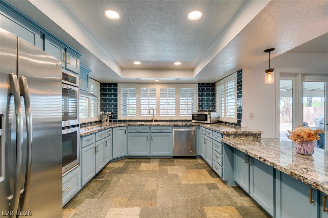 2246 Almart Circle, Henderson, NV 89014 Polished granite countertops and natural stone tile flooring anchor this bright, modern kitchen space.