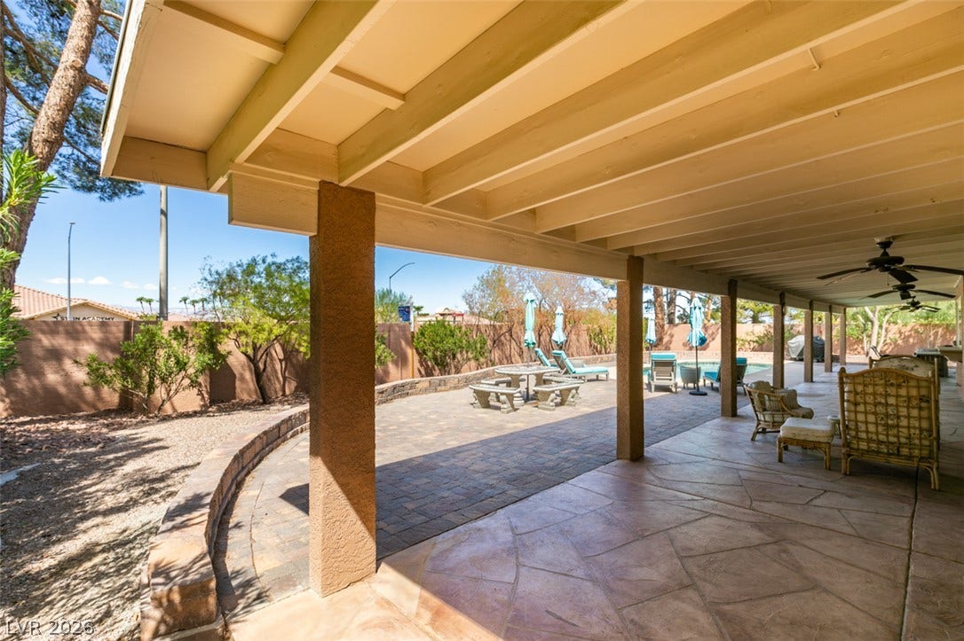 2246 Almart Circle, Henderson, NV 89014 Sheltered by a beamed patio cover, this outdoor space overlooks a brick terrace and pool.