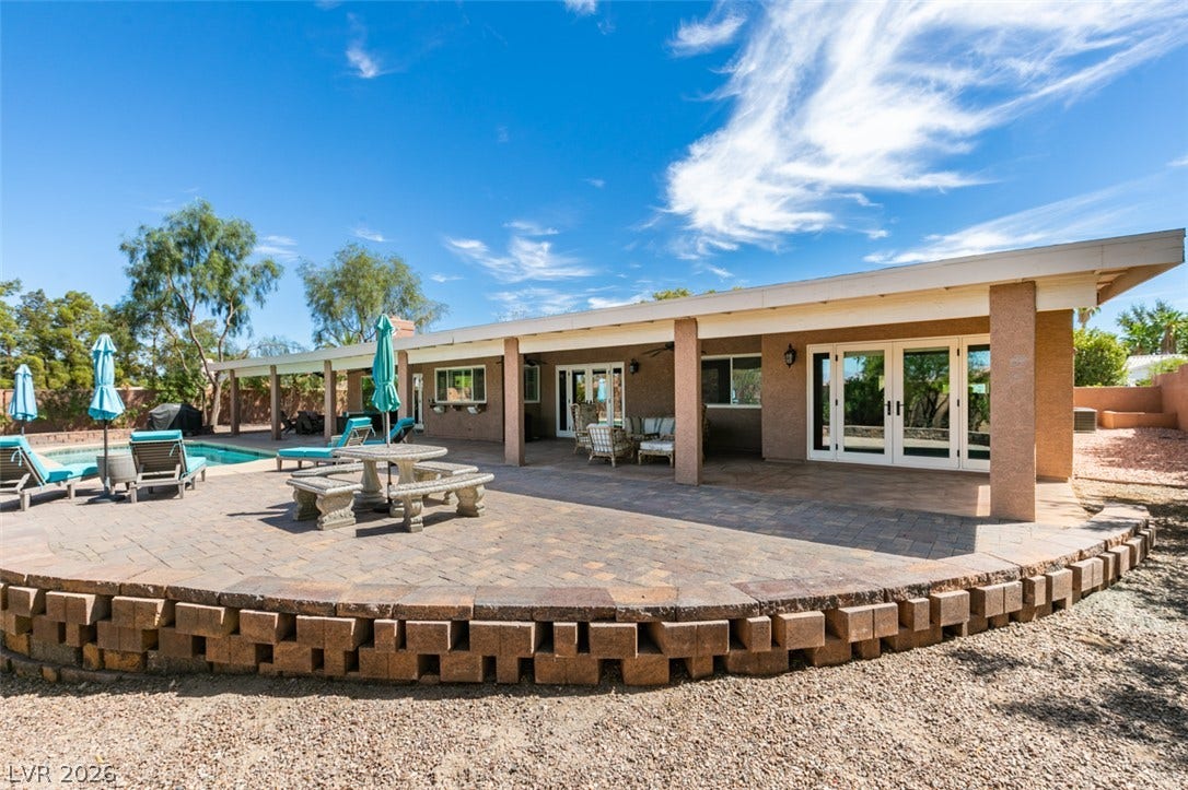 2246 Almart Circle, Henderson, NV 89014 An expansive paver patio shaded by a covered porch overlooks the sparkling pool backyard.
