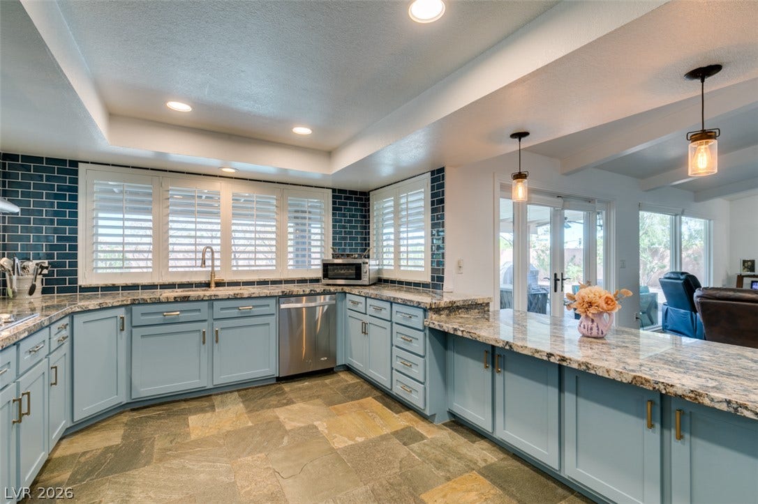 2246 Almart Circle, Henderson, NV 89014 Gleaming stone countertops and textured tile floors define this modern, well-appointed cooking space.