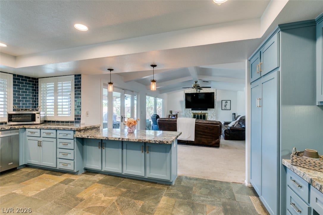 2246 Almart Circle, Henderson, NV 89014 Natural stone tile floors and premium granite countertops frame an airy, open layout.