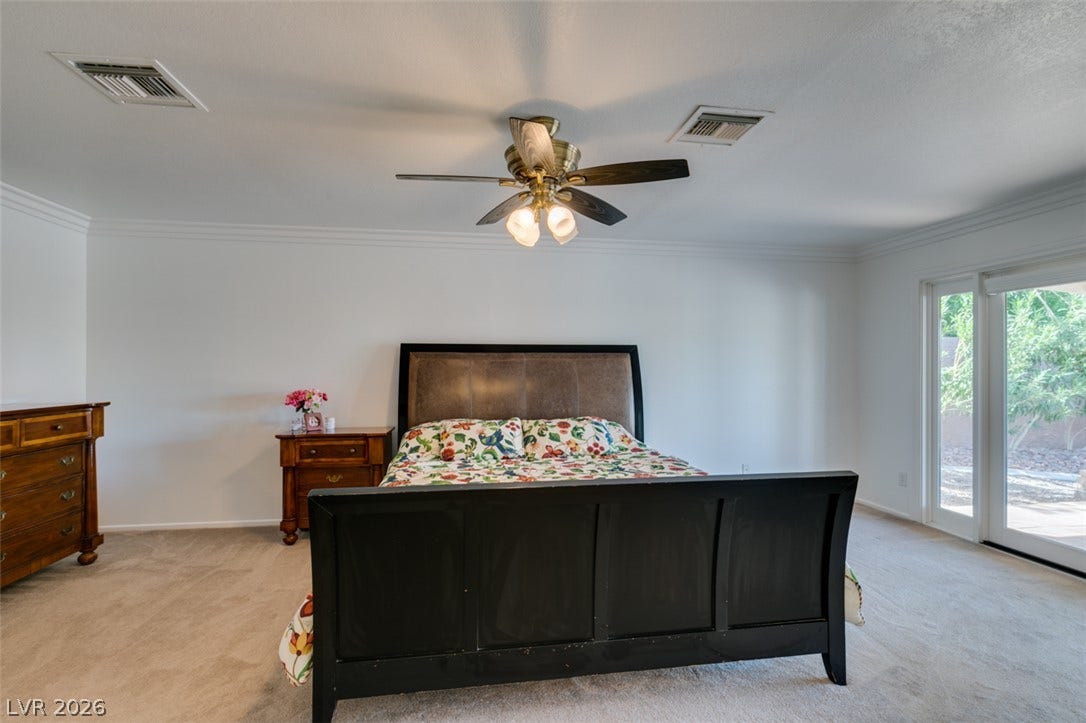 2246 Almart Circle, Henderson, NV 89014 Crown molding and glass sliding doors framing outdoor views enrich this carpeted space.